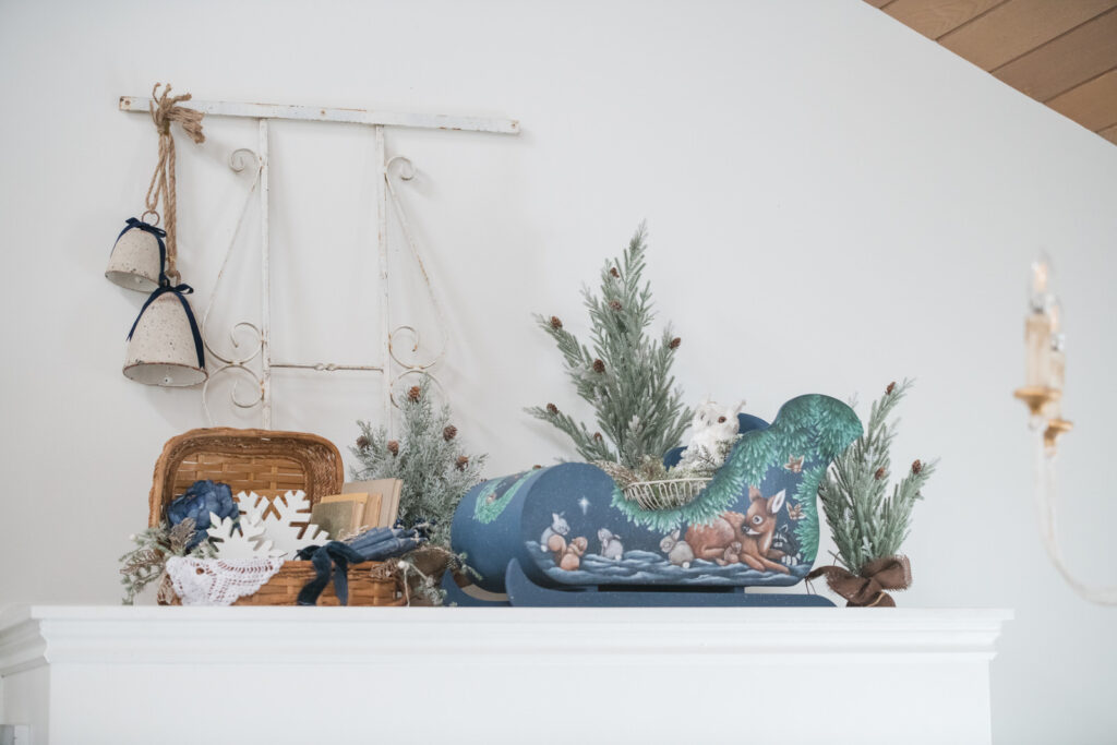 Area above the closet, styled for Christmas with the sleigh and vintage pieces with small Christmas trees and bells