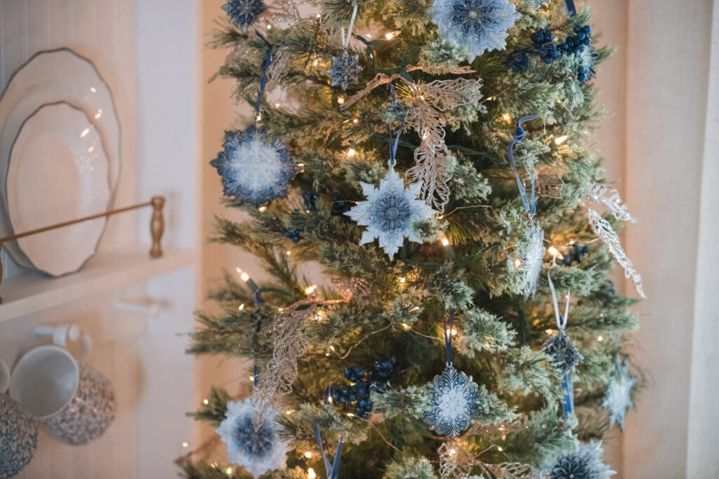 Pencil tree, decorated with handmade snowflake ornaments in blue white and gold 