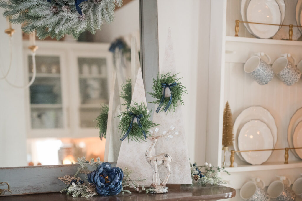 DIY textured trees with mini wreaths. Styled on a China cabinet in the dining room in front of a mirror with some Christmas greenery. 