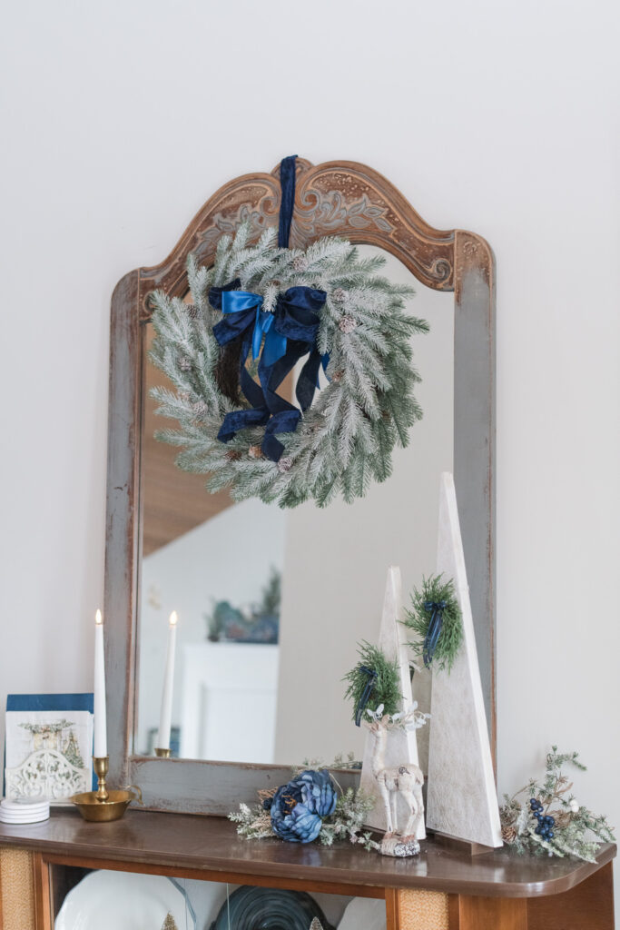 Mirror in dining room, decorated for Christmas above a China cabinet with Christmas decor