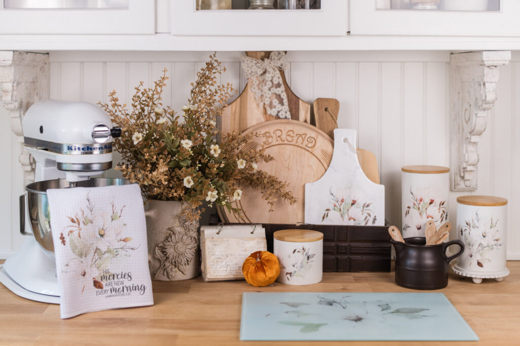 Magnolia canisters styled for fall in a cottage baking nook with a velvet pumpkin