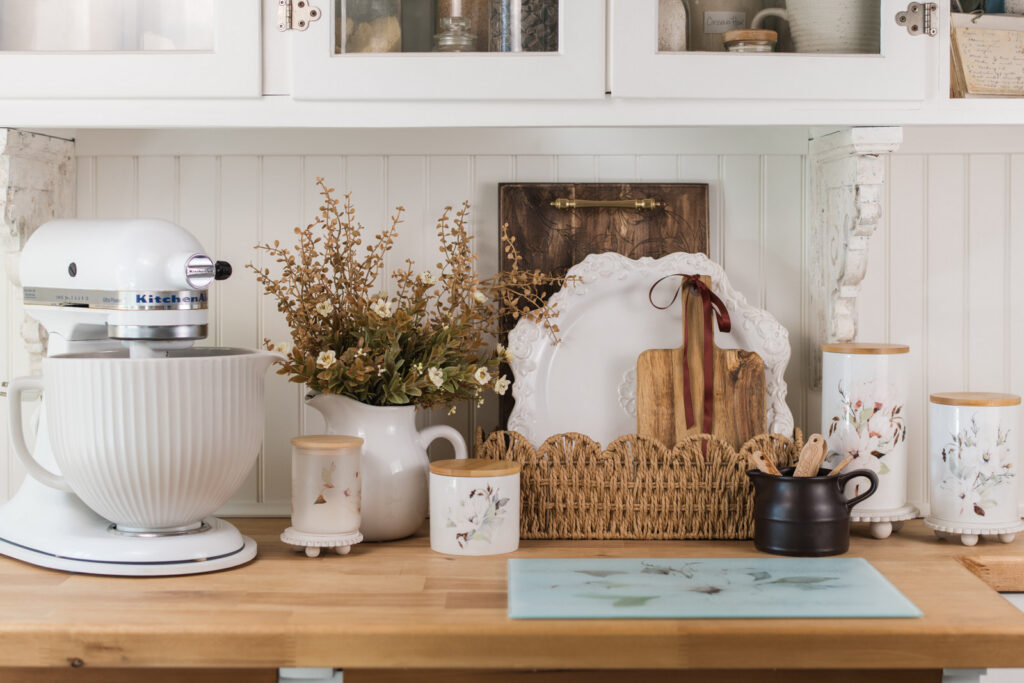 Magnolia engraved tray and trivet styled with a serving platter in a scalloped basket for kitchen decor