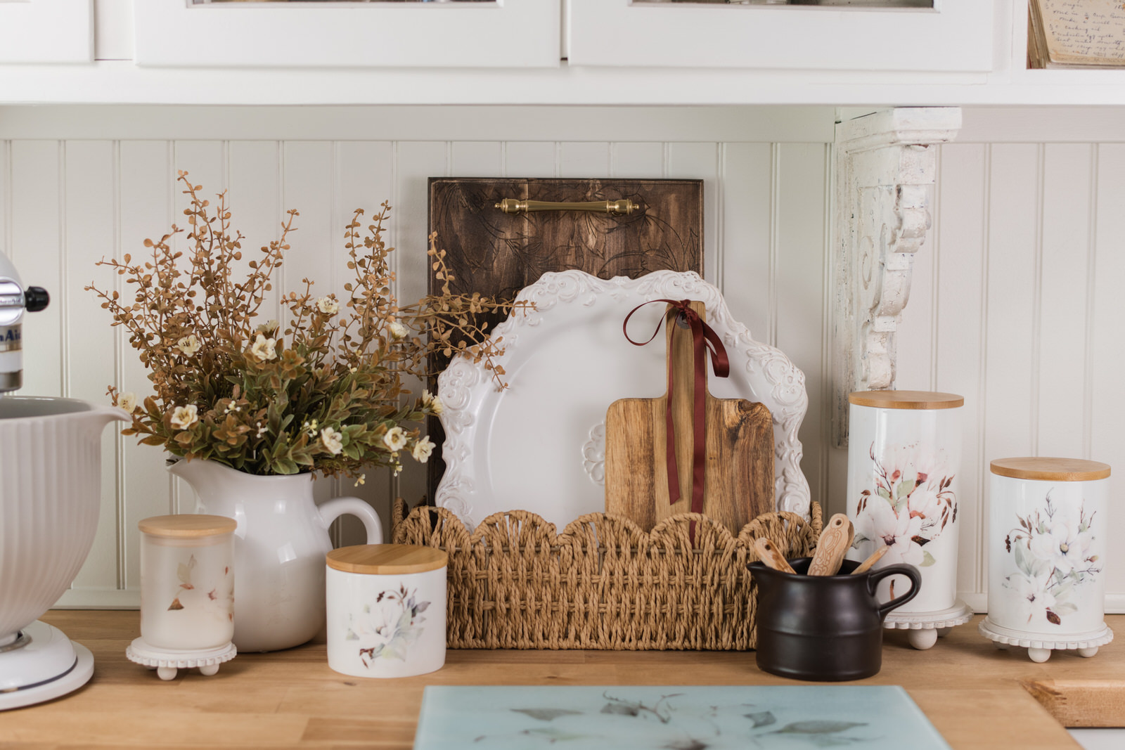 cottage baking nook styled for fall with trays and a platter in a scallop basket