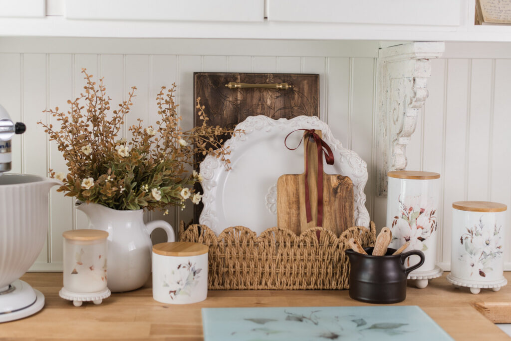 Magnolia engraved tray and trivet styled with a serving platter in a scalloped basket for kitchen decor