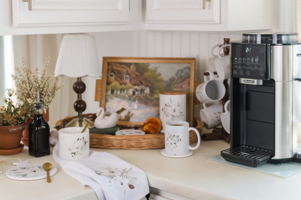 Magnolia collection fall coffee bar with mugs, canister, and coffee maker styled on a kitchen counter
