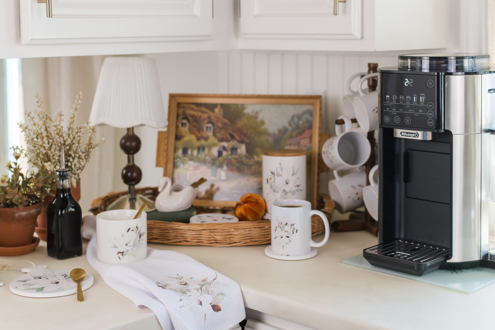 Magnolia collection fall coffee bar with mugs, canister, and coffee maker styled on a kitchen counter