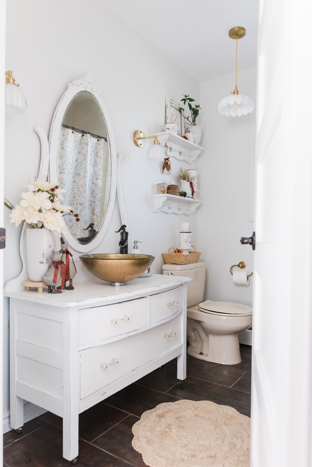 Guest bathroom styled with simple autumn bathroom decor, Magnolia pieces, pumpkins, and warm ribbon