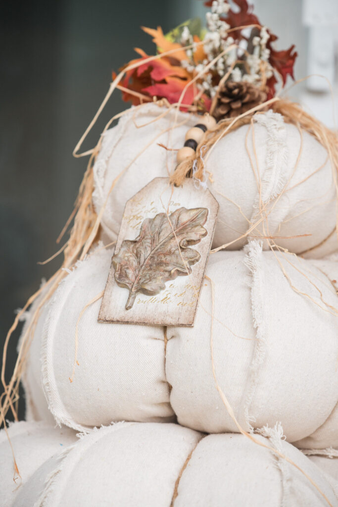 Close up of a tag handmade hanging off of drop cloth pumpkin topiaries