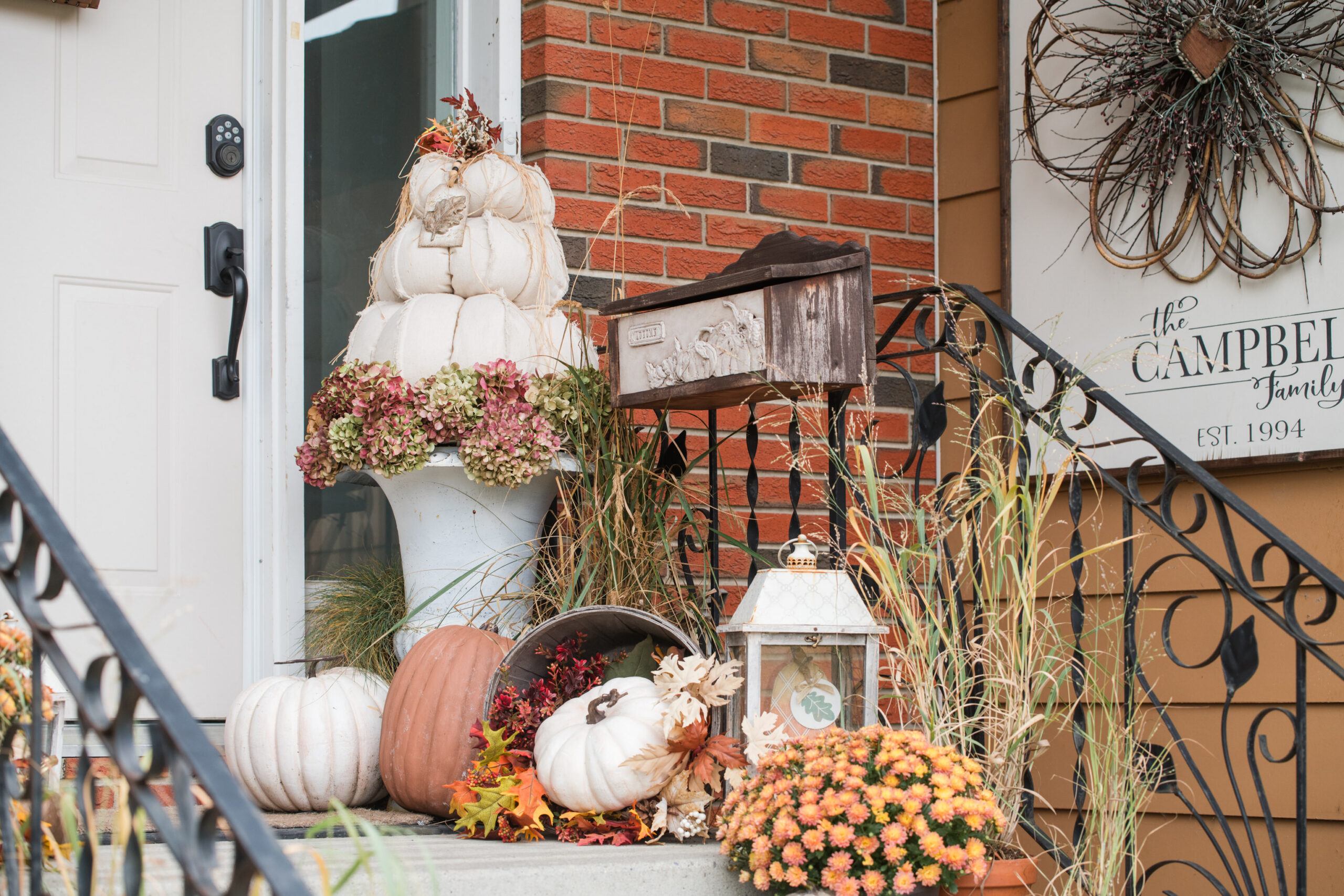 Autumn decor on a front step with DIY pumpkins, drop cloth topiary pumpkins, mums, fall grasses, and an autumn mailbox