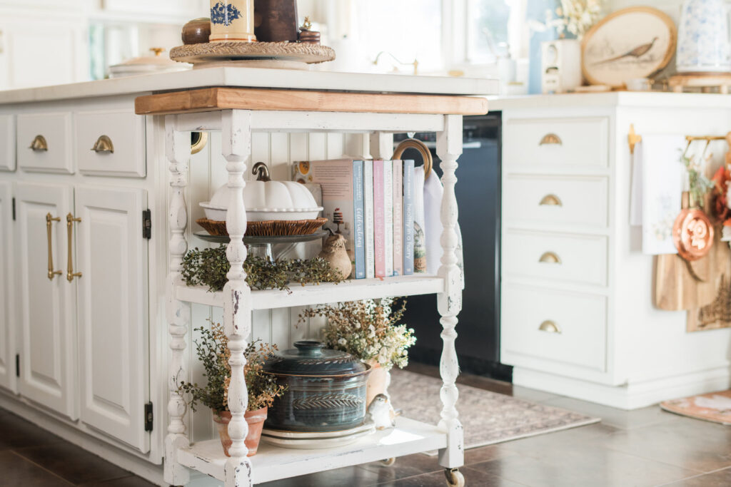 Painted kitchen cart styled for fall with cookbooks and pottery