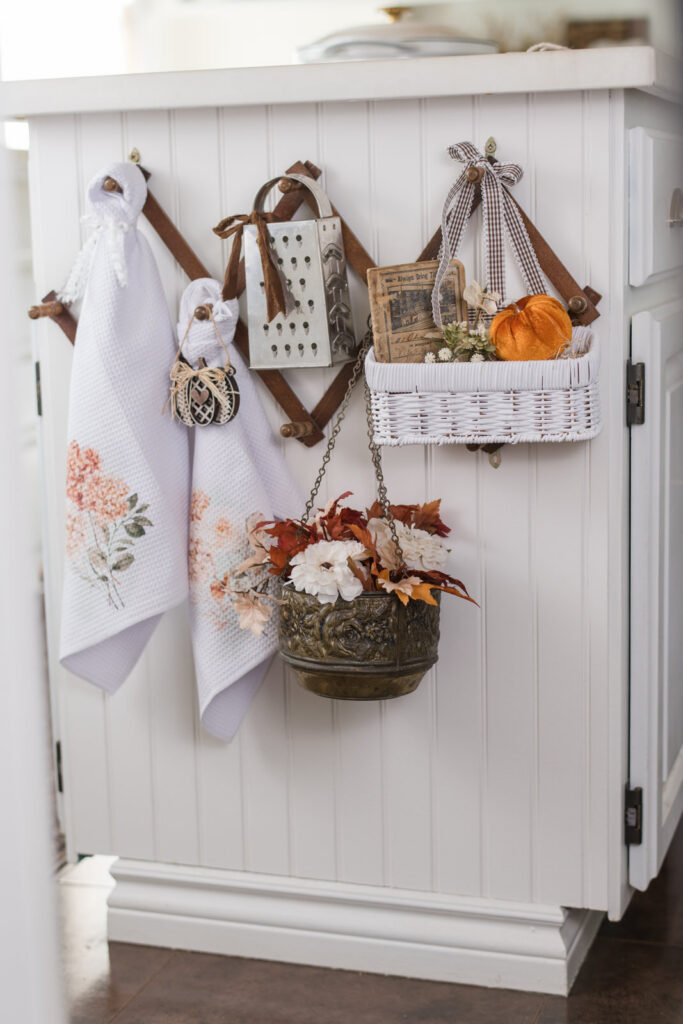 Fall tea towels displayed on an accordion rack in the kitchen